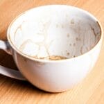 A white coffee cup with a clean exterior but stained and dirty interior, illustrating the biblical warning against appearing clean outwardly while harboring sin inwardly.