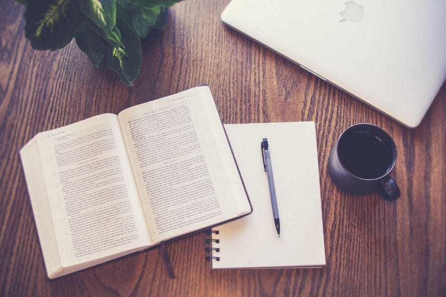 Open Bible and notebook on a wooden table, reflecting Christian planning and spiritual priorities for the new year